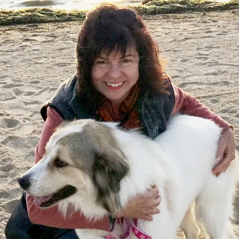 Woman with her white dog at the beach